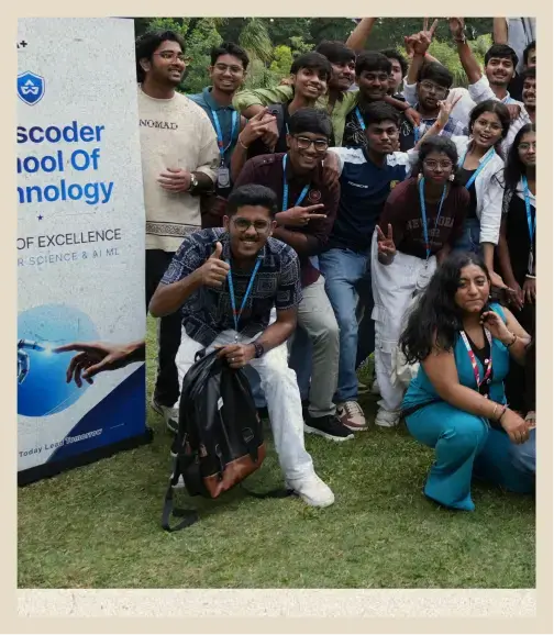 Batch photo on the campus lawn beside the Bosscoder School of Technology banner